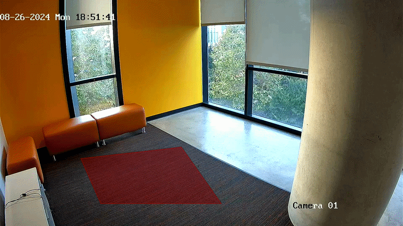 A small modern lobby area is shown from the perspective of a security camera labeled Camera 01