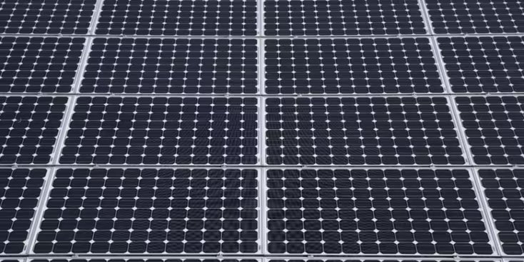 A detailed, close-up view of multiple solar panels arranged in a grid pattern. The panels feature a repeating array of photovoltaic cells with visible metallic grid lines.