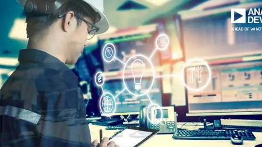 Un ingénieur portant un casque de sécurité utilise une tablette dans une salle de contrôle haute technologie. Plusieurs écrans d'ordinateur affichent des données, tandis que des icônes numériques, telles qu'une ampoule et des outils, sont superposées, suggérant innovation et technologie. Le texte 'ANALOG DEVICES' et 'AHEAD OF WHAT'S POSSIBLE' est clairement visible dans le coin supérieur droit.