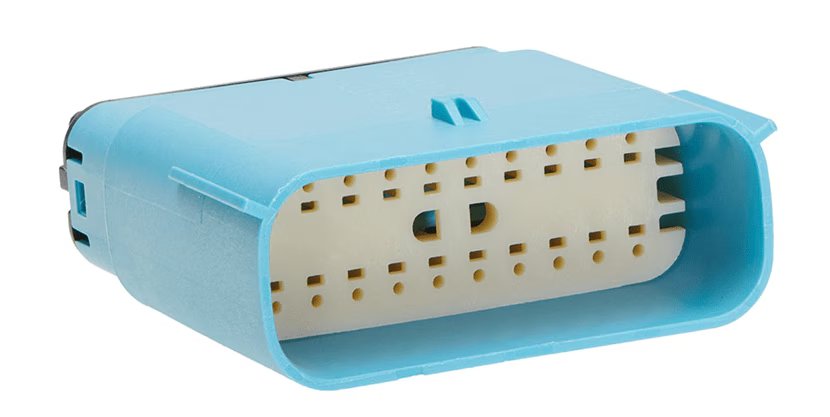 A blue rectangular electrical connector with multiple pin slots is shown in close-up against a white background. The connector features a cream-colored insert with numerous small holes for electrical contacts.