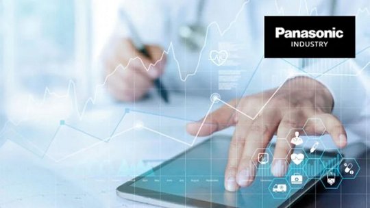 Une personne en blouse blanche interagit avec une tablette, suggérant un contexte professionnel ou technique. L'image présente des graphiques de données numériques et des icônes, indiquant une analyse technologique ou industrielle. Le logo Panasonic Industry est clairement visible dans le coin supérieur droit.