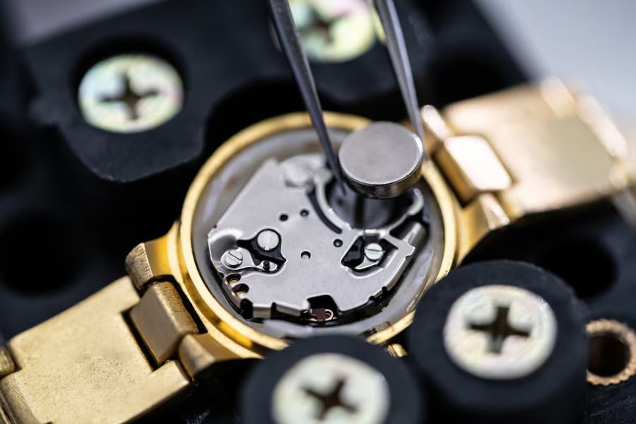 A detailed view of a watch mechanism being repaired with precision tools.