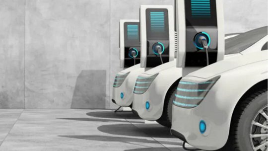 현대적인 흰색 전기차 3대가 나란히 주차되어 있으며, 각각 세련된 충전기에 연결되어 있습니다.