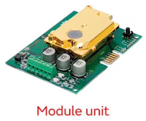 A close-up image of an electronic module unit featuring a prominent gold-colored component mounted on a green printed circuit board. The board includes several capacitors, connectors, and a visible push button.