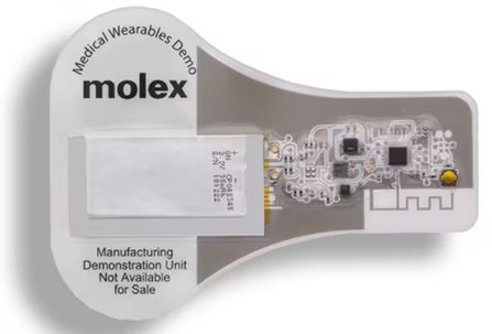 This image shows a Molex medical wearables demonstration unit, featuring a visible electronic circuit and battery component. The unit is labeled as a manufacturing demonstration and is not available for sale.
