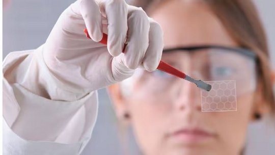 A person wearing a white medical glove holds up a rectangular card towards the camera.