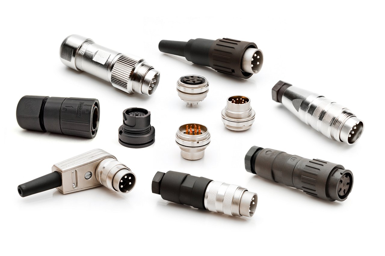 A variety of industrial electrical connectors are arranged on a clean white surface.