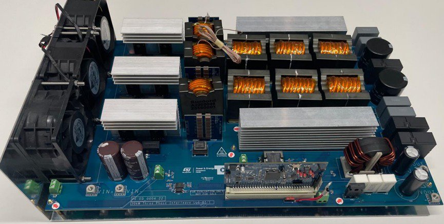 A detailed view of an electronic circuit board featuring multiple heat sinks, capacitors, and cooling fans. 