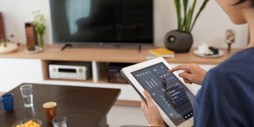 Image of woman controlling home security system on smart device