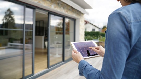 Image of woman using remote home control system on digital interface