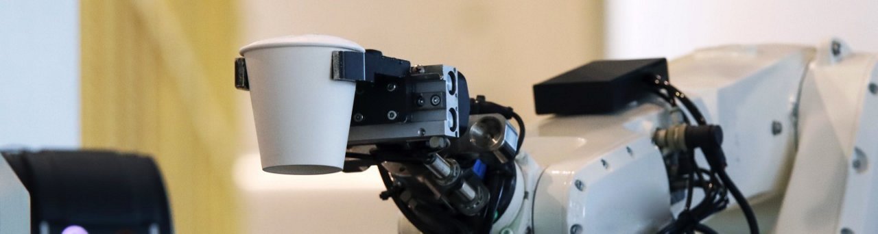 Bras robotique tenant un gobelet en papier