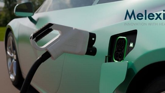 Une vue rapprochée d'une voiture électrique en cours de recharge, avec un logo Melexis visible et le slogan 'Innovation with Heart'.