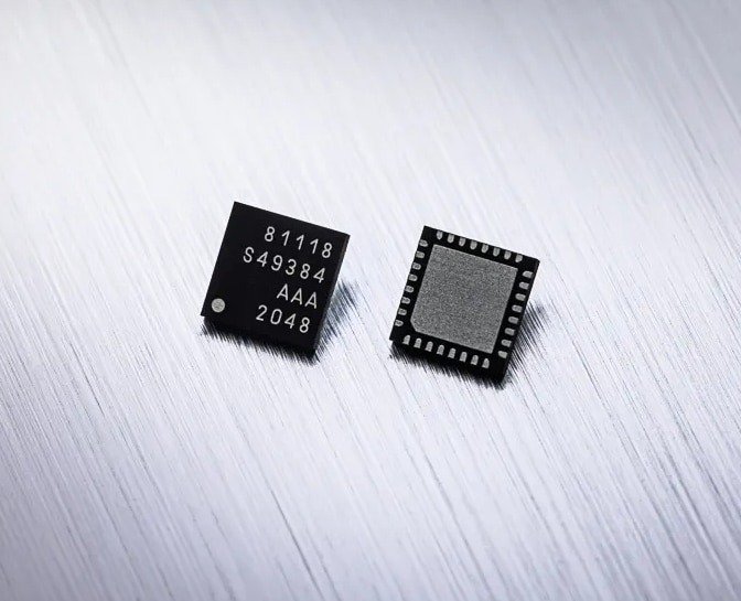 Two small microchips are displayed on a brushed metallic surface. 