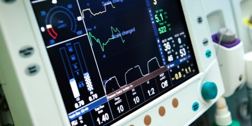 Close-up of a medical monitor showing various vital signs and metrics in a clinical setting.