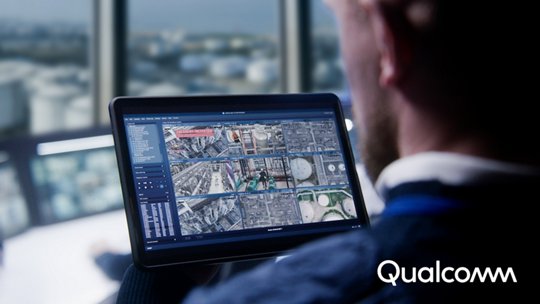 A person holds a tablet displaying multiple satellite map views and data panels.