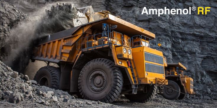 Un énorme camion-benne jaune de chantier est capturé en train de décharger des roches dans un environnement de carrière accidenté.