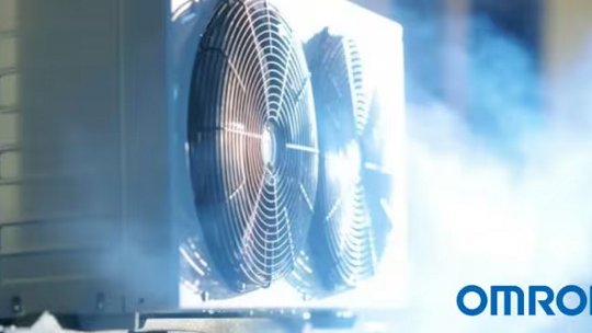 Una persona che indossa un maglione rosso e un cordino giallo è vista lavorare su un laptop in una sala server.