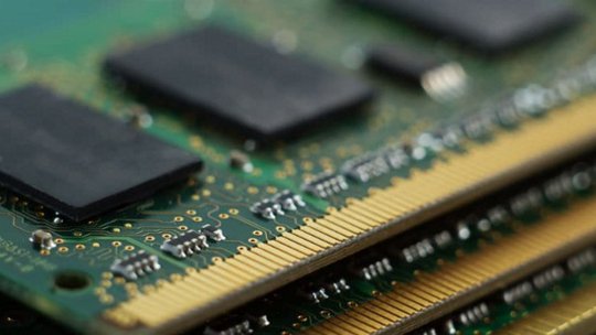 This image shows a detailed close-up of several computer RAM memory modules stacked together.