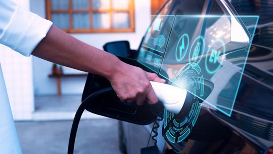 A close-up of an electric car being charged, featuring a futuristic digital interface overlay. 