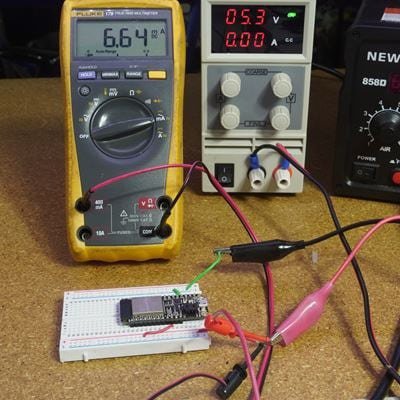 A digital multimeter displays a reading of 6.64 A next to a bench power supply showing 0.53 V and 0.00 A.