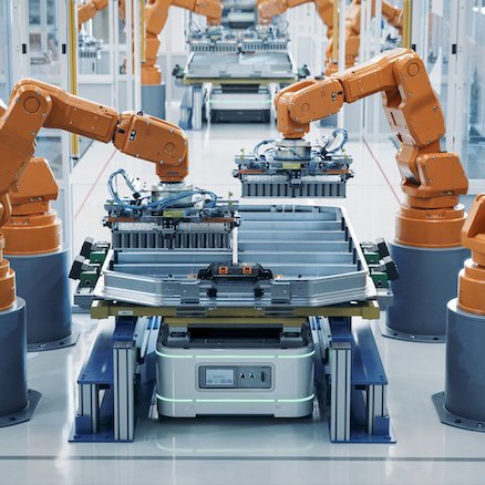 Modern Electric Car Automated Smart Factory. EV Battery Pack Production Line Equipped with Orange Advanced Robot Arms. Row of Robotic Arms inside Bright Plant Assemble Batteries for Automotive Industry