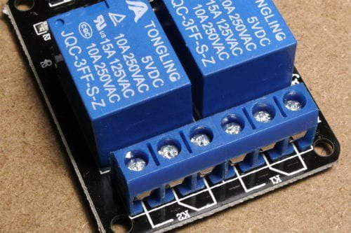 This image shows a close-up view of a Tongling relay module featuring two blue relays and a screw terminal block.