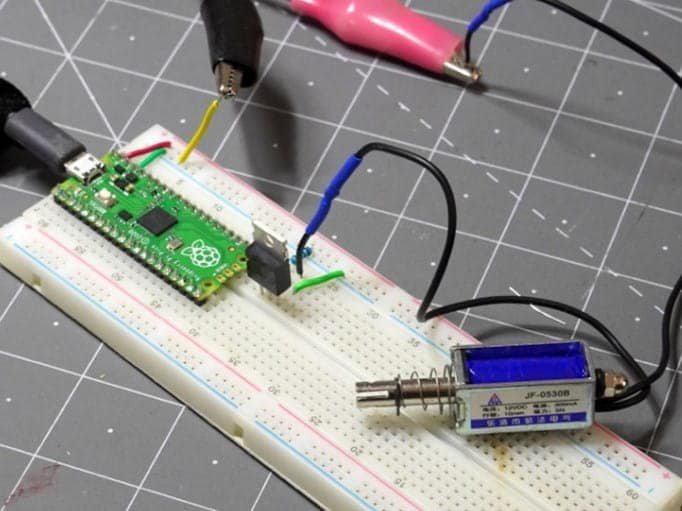 A Raspberry Pi Pico microcontroller is connected to a breadboard circuit alongside a JF-0530B solenoid.