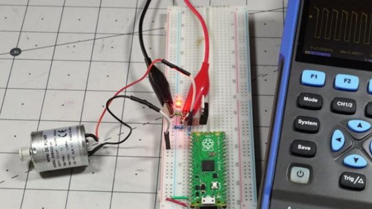 Un microcontrollore Raspberry Pi Pico è collegato a un circuito su breadboard, controllando un piccolo motore DC.