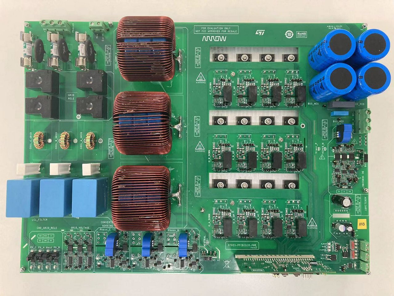 A detailed view of an electronic circuit board featuring multiple components, including coils, capacitors, and integrated circuits. The board is labeled with 'Arrow' and 'ST' logos, indicating clear branding. 