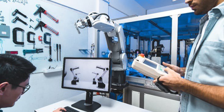 A robotic arm is showcased in a modern industrial setting, with a technician operating a control device nearby. 