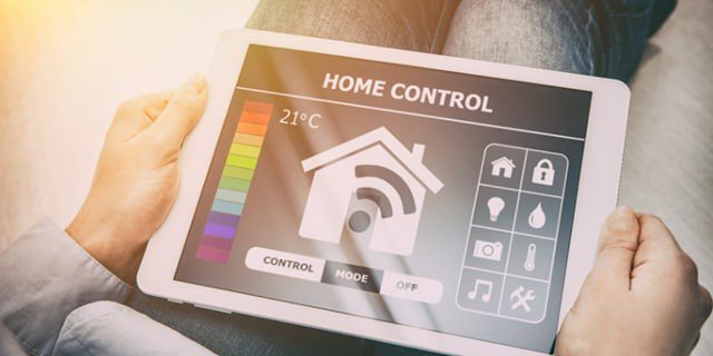 A tablet screen displays a smart home control interface with icons for temperature, lighting, and security. 