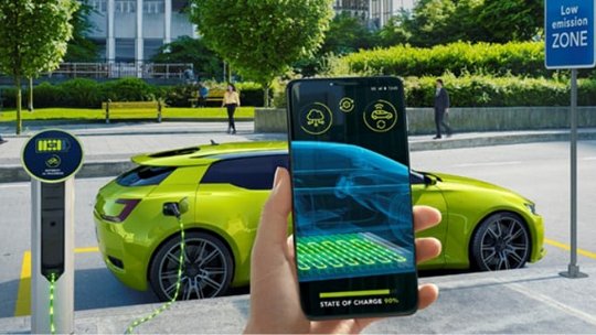 저배출 구역의 충전소에 밝은 녹색 전기차가 주차되어 있습니다.