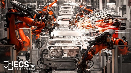 An unfinished car body is positioned on an automated assembly line surrounded by multiple robotic arms.