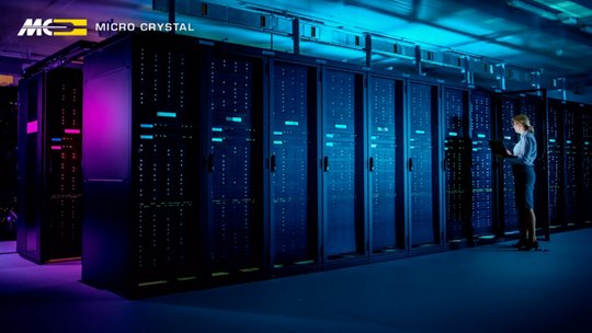 A technician stands in front of tall server racks in a modern data center.