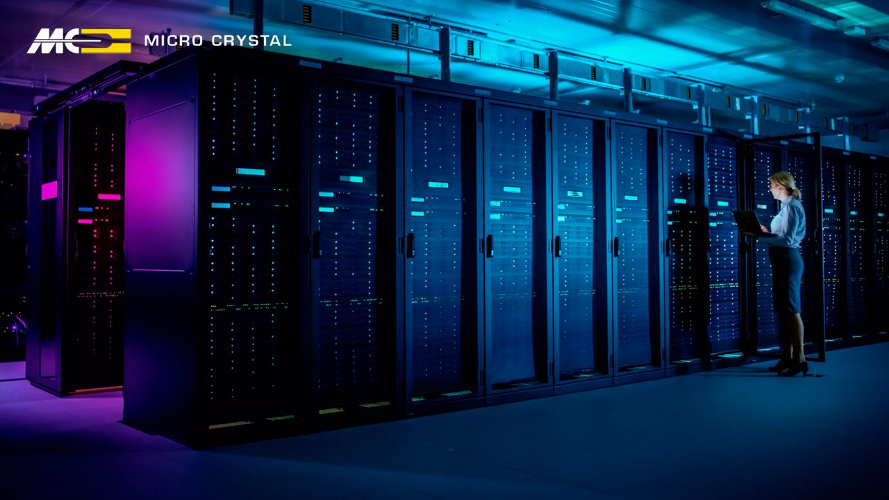 A technician stands in front of tall server racks in a modern data center.