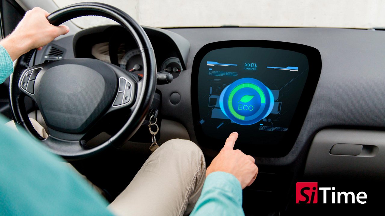 A person seated in a car interacts with a large digital dashboard display. 