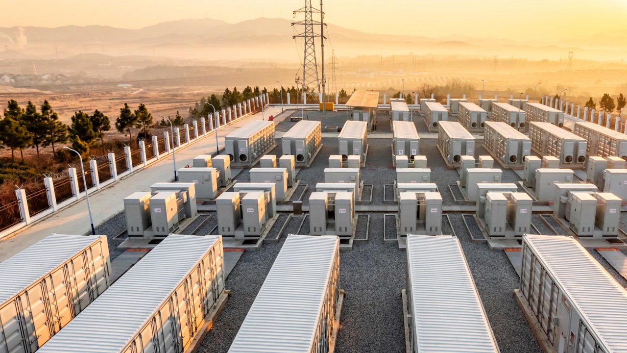 An expansive industrial site features rows of large white container units arranged in a grid. 