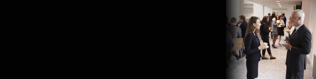 一群商业专业人士聚集在现代室内场所，进行交谈和社交。