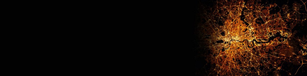 该图像显示了城市夜晚的详细航拍视图，照亮的街道和道路形成复杂的网络。