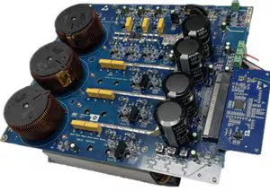 A detailed blue electronic circuit board is shown, featuring multiple large capacitors, copper coils, and various integrated circuits. The board is populated with yellow and black components, and visible traces connect the elements.