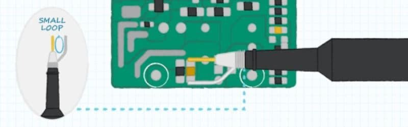 A small loop tool is shown in use on an electronic circuit board.