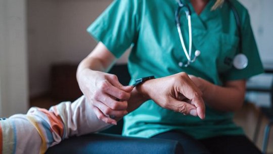 Image of nurse assisting patient with smart watch