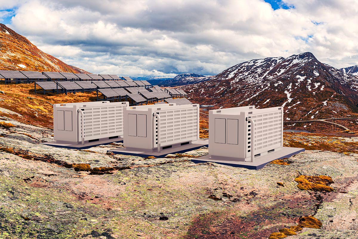 Three large battery storage units sit on rocky terrain in a remote mountainous landscape.
