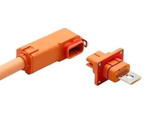A close-up of an orange high-voltage electrical connector and its matching socket. The connector features a rectangular housing and is paired with a socket that has a metallic contact plate.