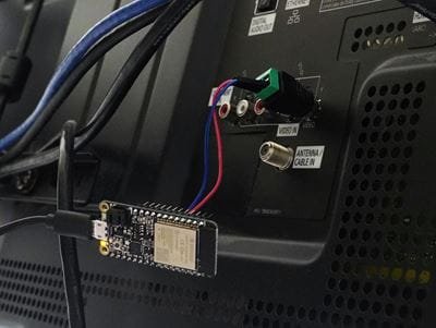 ESP32 development board mounted behind a display and connected to wiring and terminal blocks on the back panel.