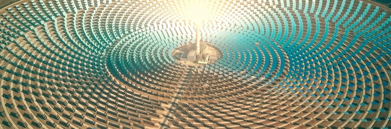 A large solar power plant featuring an array of circular mirrors arranged concentrically around a central tower.