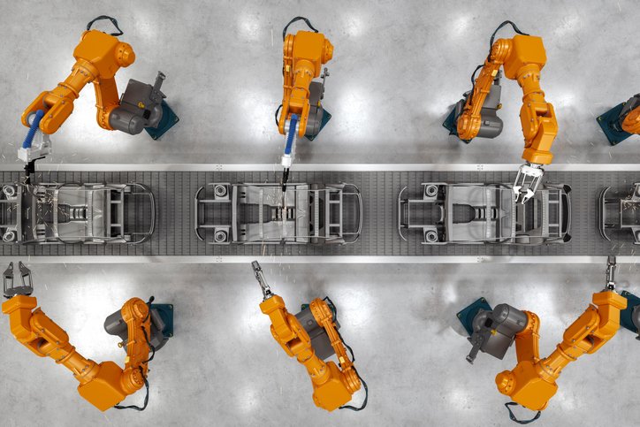 Top view of industrial welding robots at the automated car manufacturing factory assembly line.