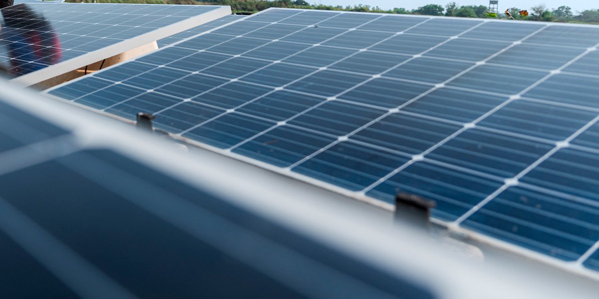 The image shows a close-up perspective of multiple solar panels arranged in rows. 