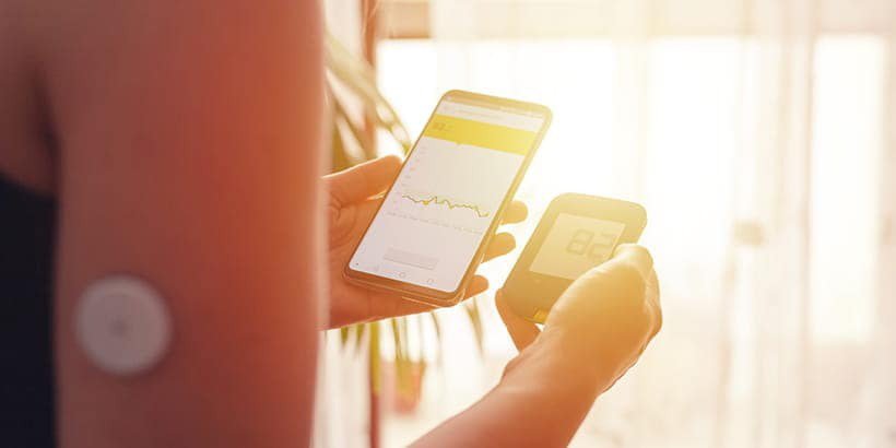 A woman is seen holding two electronic devices, one displaying a graph and the other showing a QR code