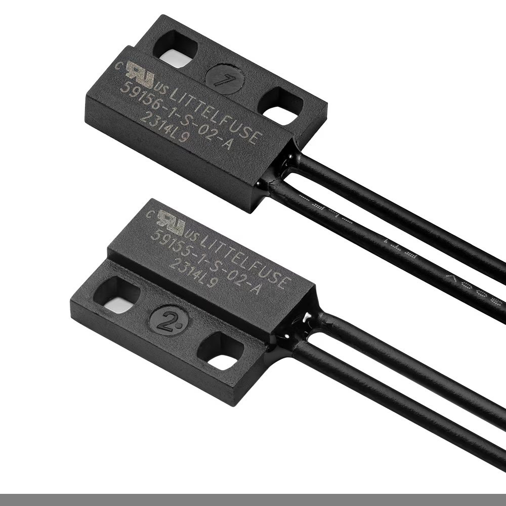 A close-up of two Littelfuse reed sensor components are shown. The model number 5935AT-02-A and the code 2314L9 are clearly visible on both units. The components are black with mounting holes and attached wires, and each is marked with a number in a circle.
